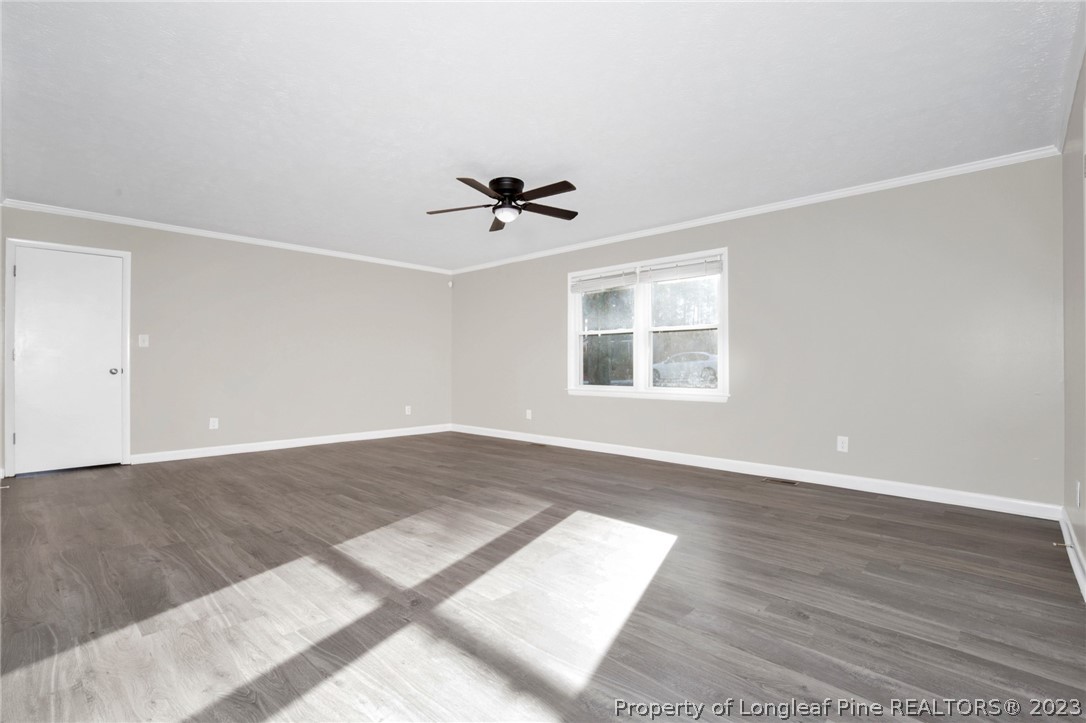 610 Arrowood Road Fayetteville, NC 28311 - Photo 9 of 26 an empty room with wooden floor and windows