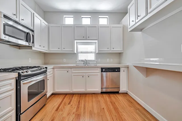 a kitchen with granite countertop wooden floors and stainless steel appliances