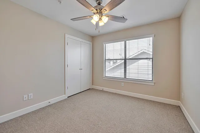 an empty room with a window and a fan