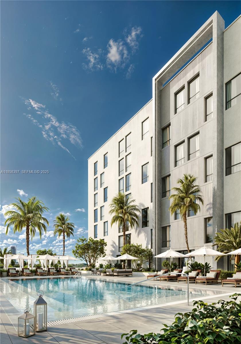 1265 Southwest 22nd Street, Unit 407 Miami, FL 33145 - Photo 11 of 17 a front view of multi story residential apartment building with yard and lake view