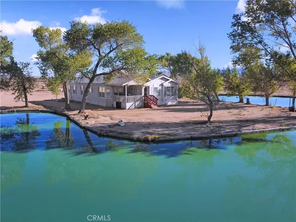 a view of a house with a yard fire pit and a large tree