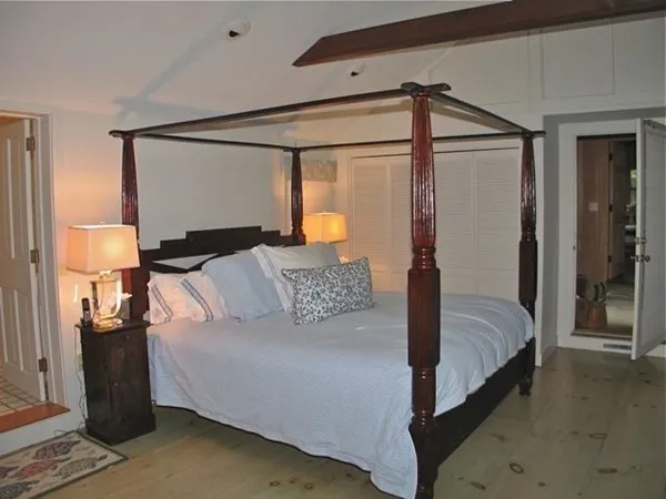 a bedroom with a large bed and a chandelier