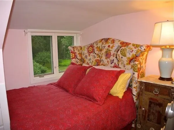 a bed sitting in a bedroom next to a window