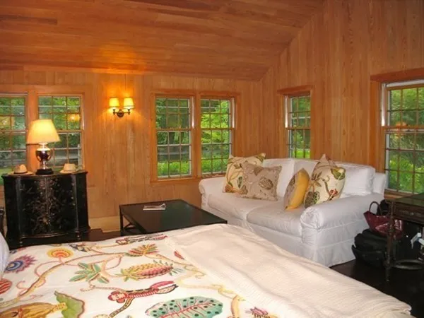 a bedroom with a bed mirror and window