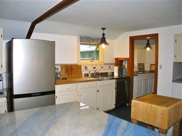 a kitchen with white cabinets and appliances