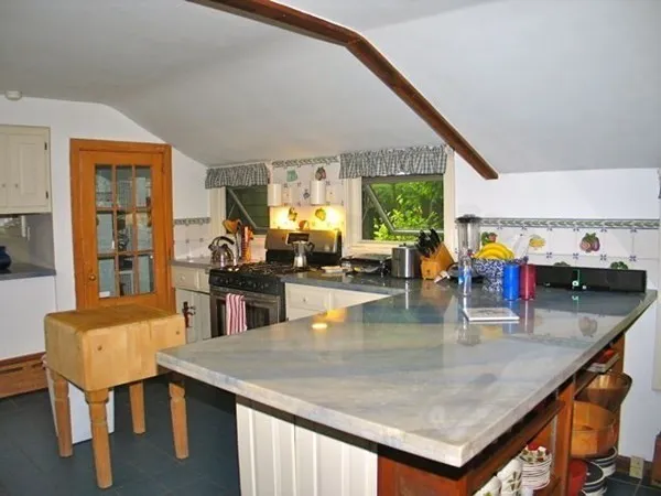 a kitchen with stainless steel appliances a stove a sink a counter space and cabinets