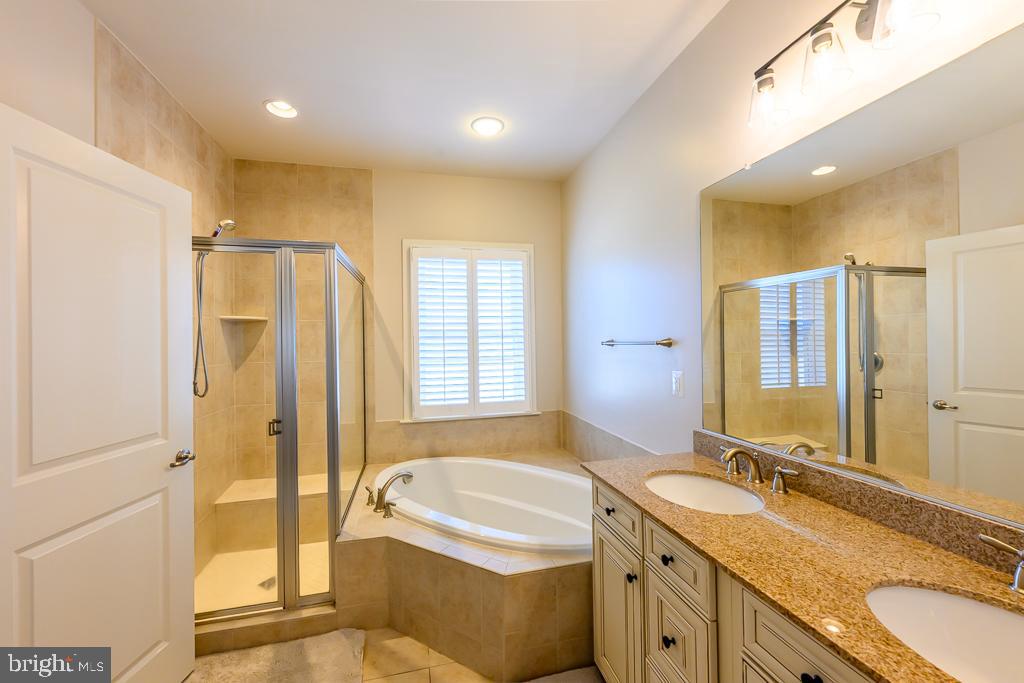 20649 Duxbury Terrace Ashburn, VA 20147 - Photo 27 of 41 a bathroom with a granite countertop tub sink and mirror