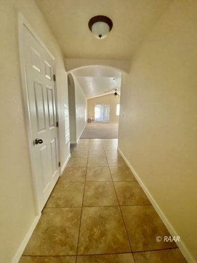935 West Wasp Avenue Ridgecrest, CA 93555 - Photo 4 of 27 a view of a hallway with wooden floor and a bathroom