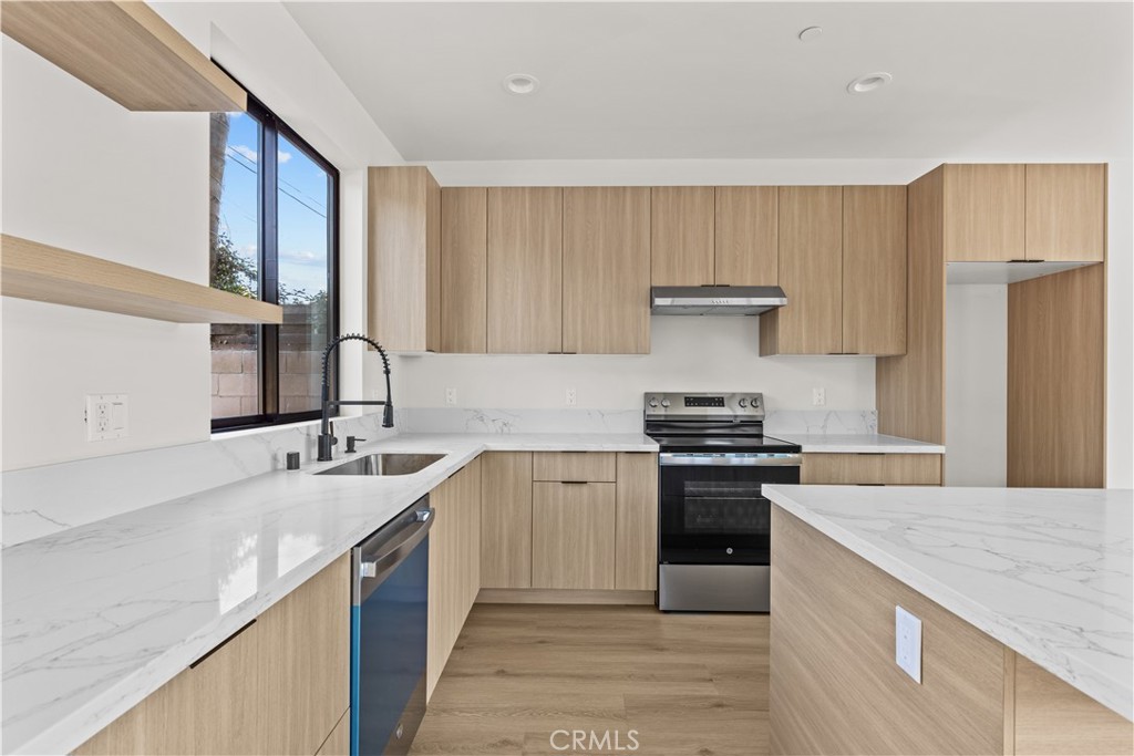 11145 Hortense Street North Hollywood, CA 91602 - Photo 4 of 15 a kitchen with a sink stove and refrigerator