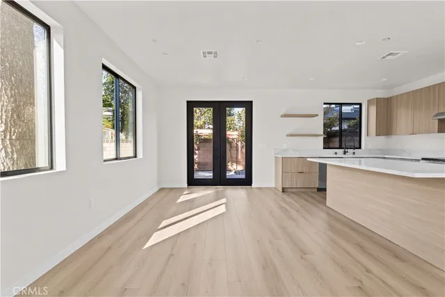 a large white kitchen with granite countertop a window and a sink