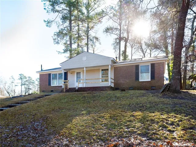 a view of a yard in front of a house with large trees