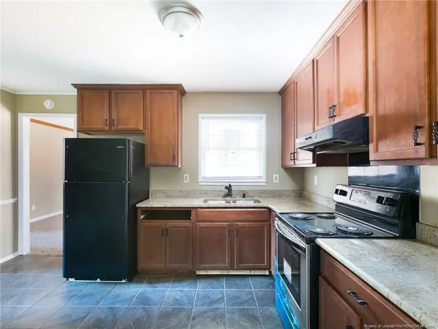a kitchen with a sink a refrigerator and cabinets