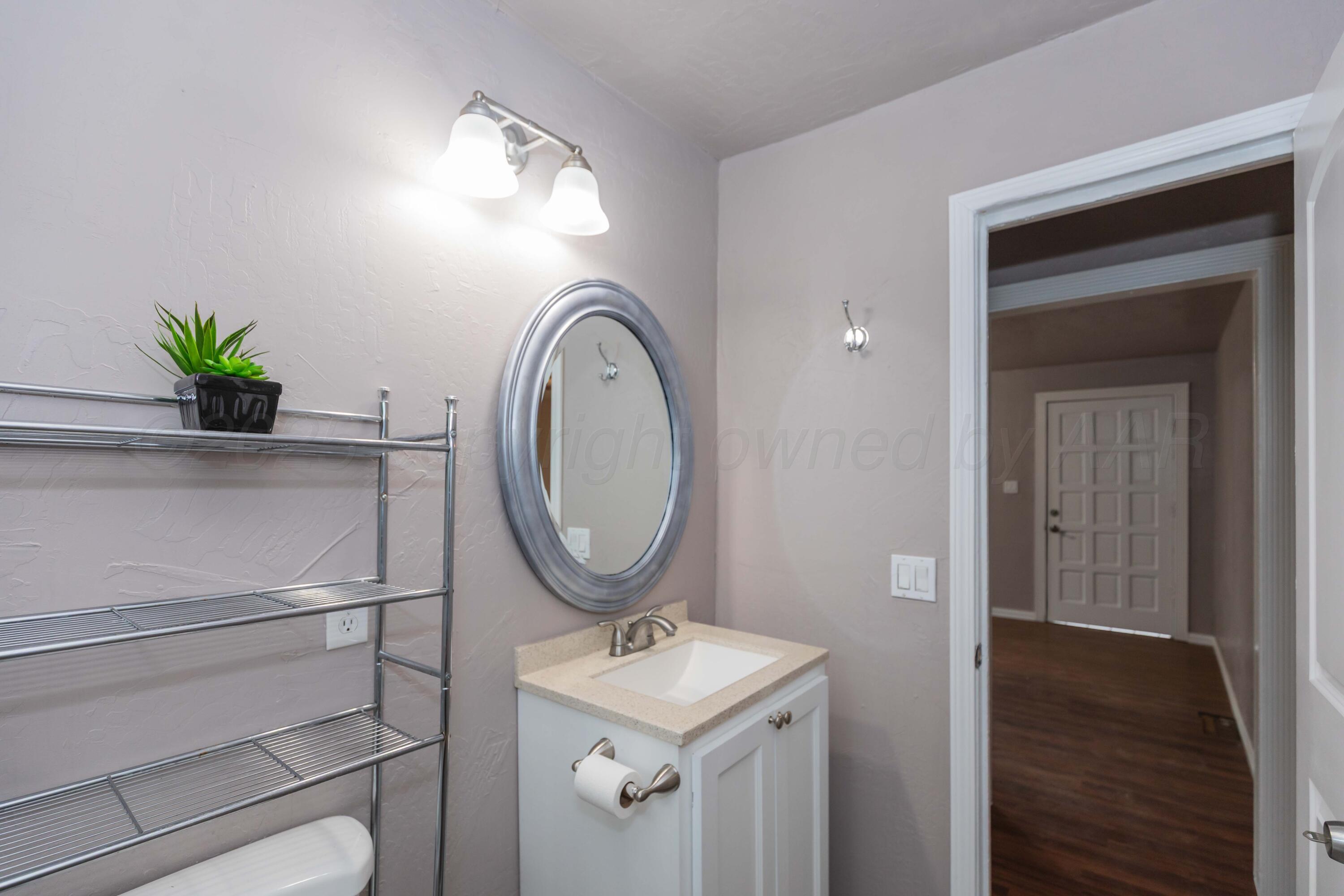 1307 North Buchanan Street Amarillo, TX 79107 - Photo 18 of 31 a bathroom with a toilet a sink and mirror