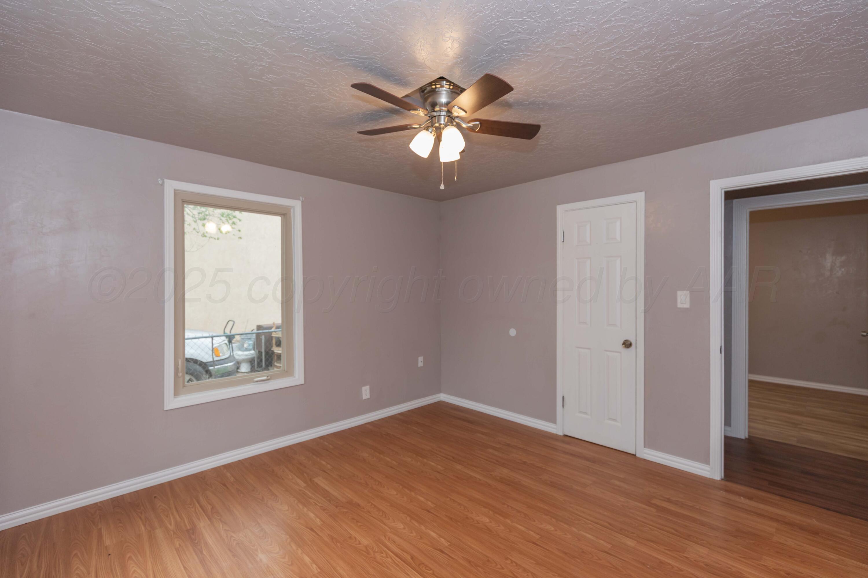 1307 North Buchanan Street Amarillo, TX 79107 - Photo 20 of 31 a view of an empty room with window and wooden floor