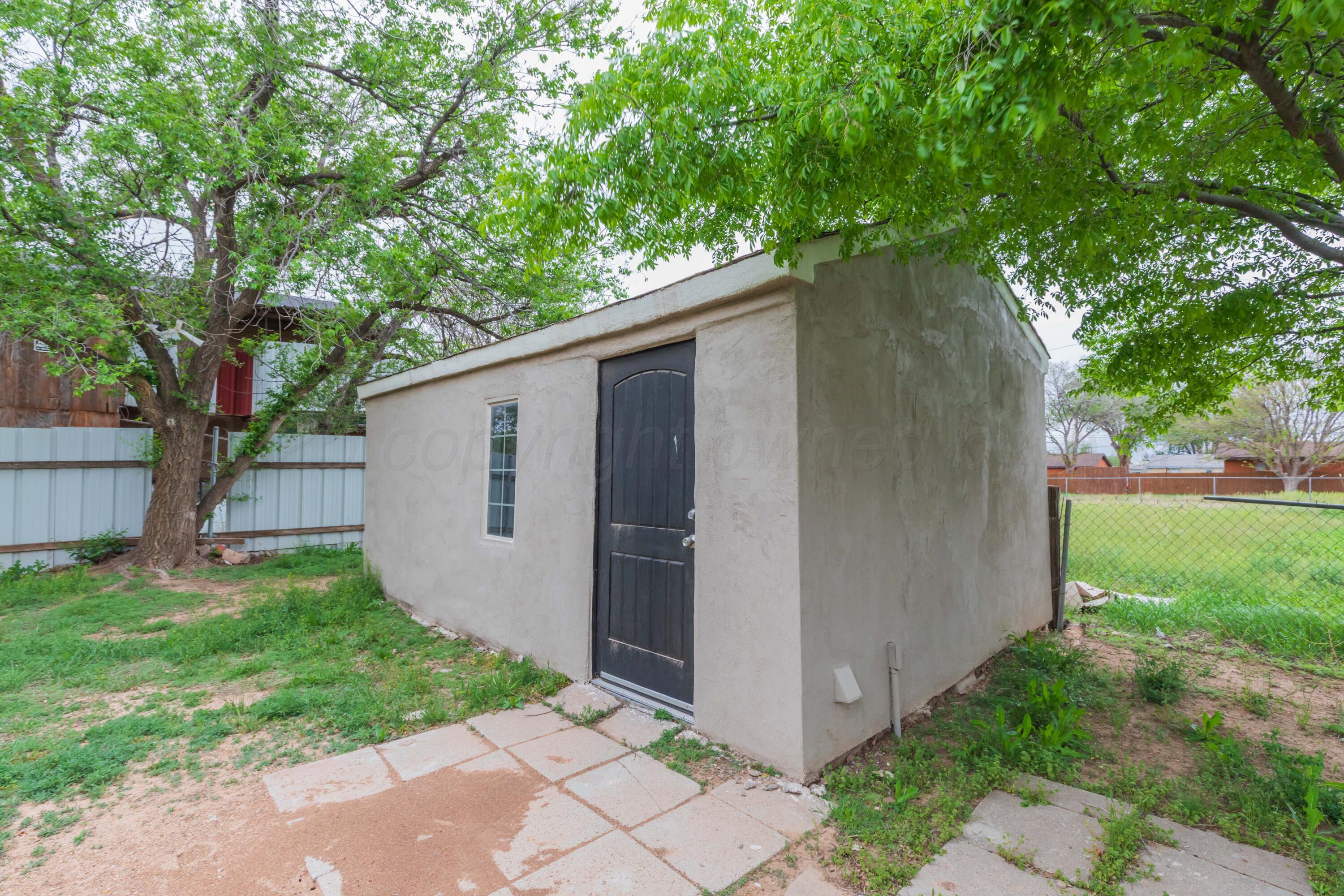 1307 North Buchanan Street Amarillo, TX 79107 - Photo 23 of 31 a backyard of a house with plants and large tree
