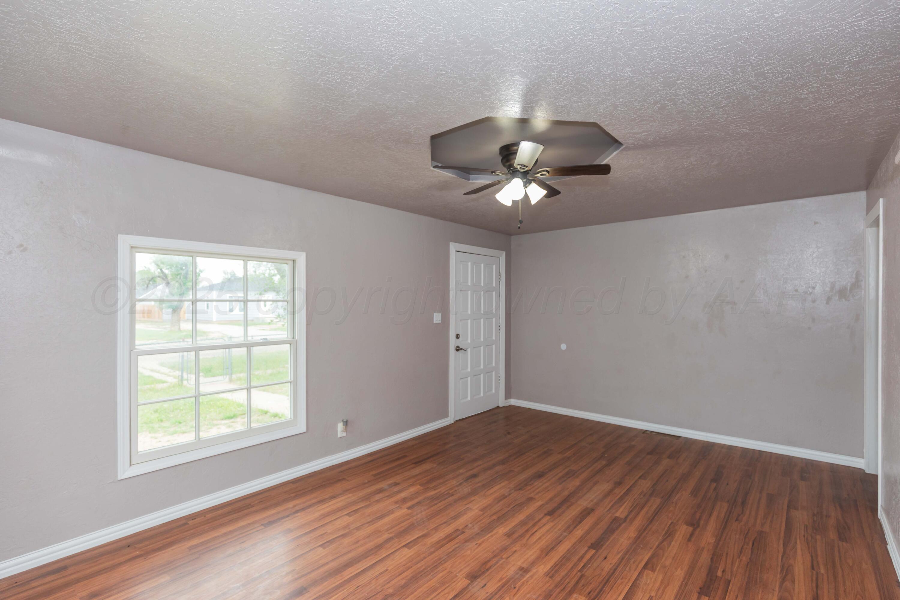 1307 North Buchanan Street Amarillo, TX 79107 - Photo 6 of 31 a view of an empty room with wooden floor and a window