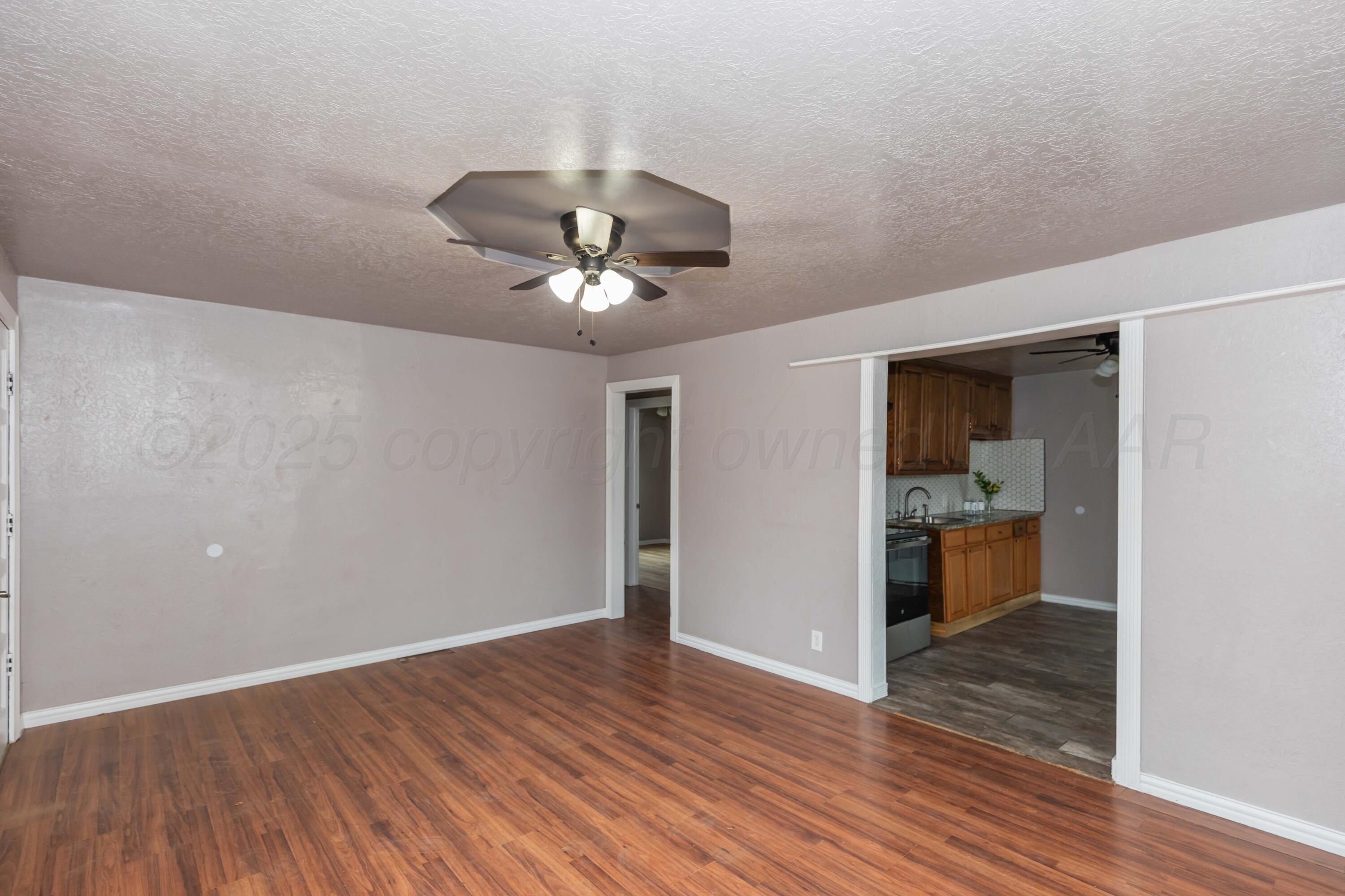 1307 North Buchanan Street Amarillo, TX 79107 - Photo 7 of 31 wooden floor in an empty room with a window