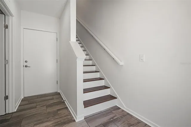 a view of a hallway with wooden floor and entryway
