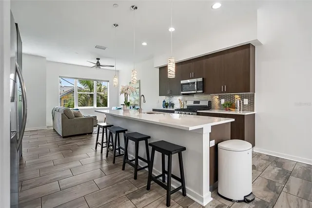 a kitchen with stainless steel appliances granite countertop a sink and a refrigerator