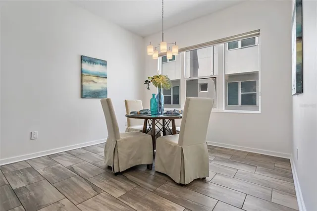 a dining room with furniture a chandelier and wooden floor