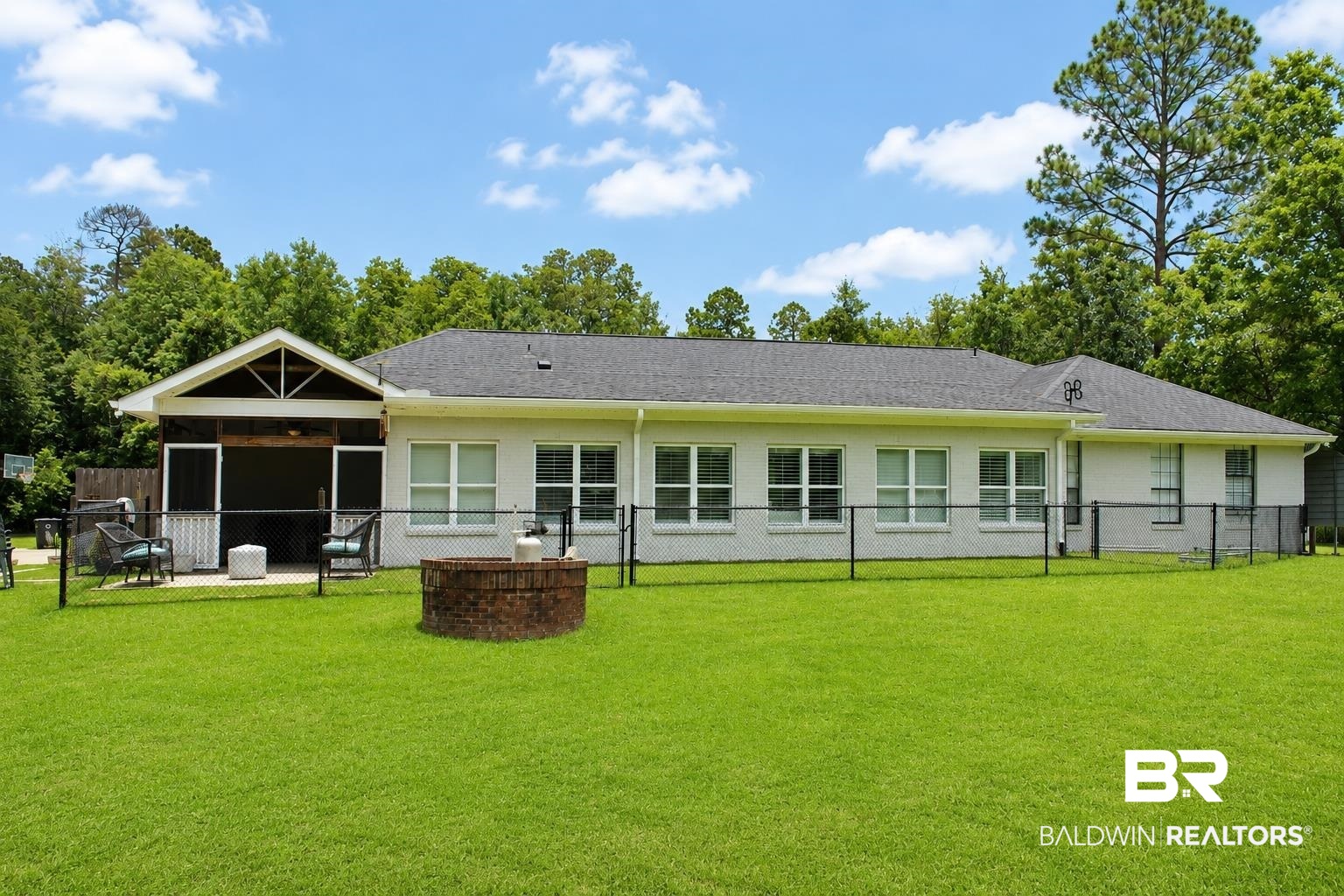 9825 Wolf Creek Ridge Elberta, AL 36530 - Photo 52 of 76 Expansive backyard featuring a screened-in patio, a brick fire pit, and a black chain link fence