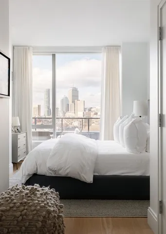 a spacious bedroom with a bed and a lamp on table