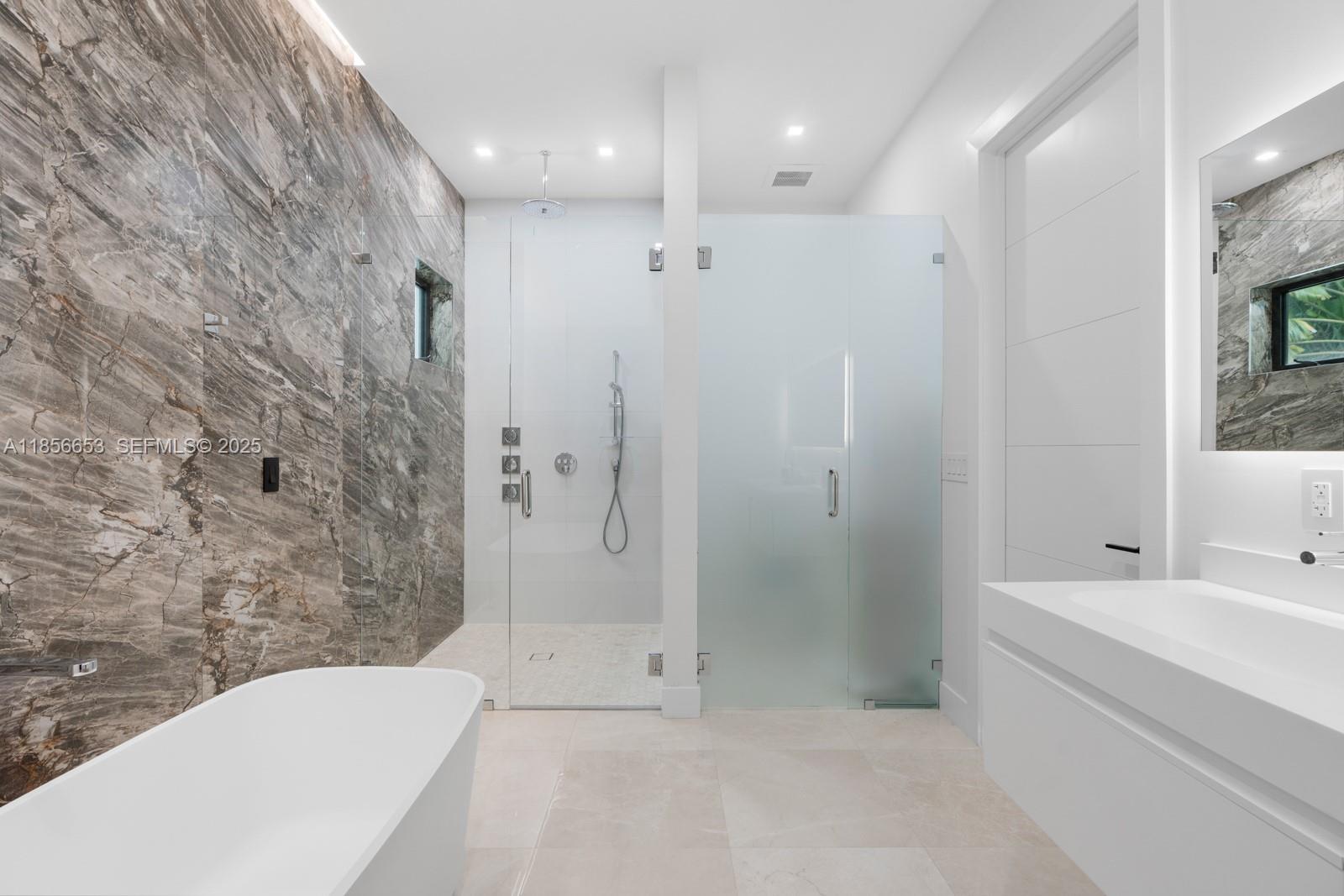 80 Northwest 129th Avenue Miami, FL 33182 - Photo 16 of 34 a bathroom with a bathtub and a shower