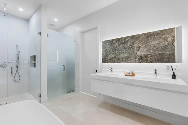 a bathroom with a double vanity sink mirror and bathtub