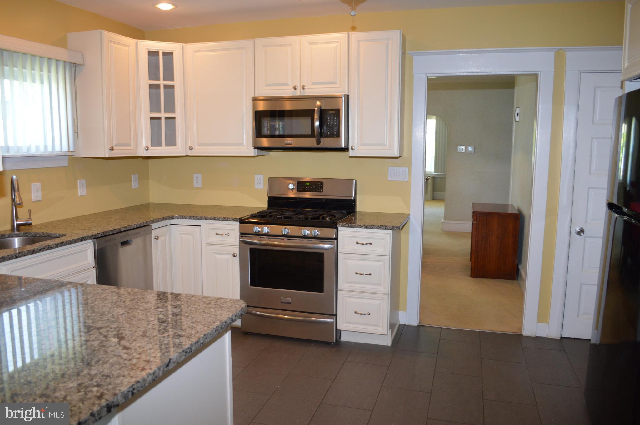 204 Ryers Avenue Cheltenham, PA 19012 - Photo 19 of 51 a kitchen with stainless steel appliances granite countertop a stove a sink and a microwave