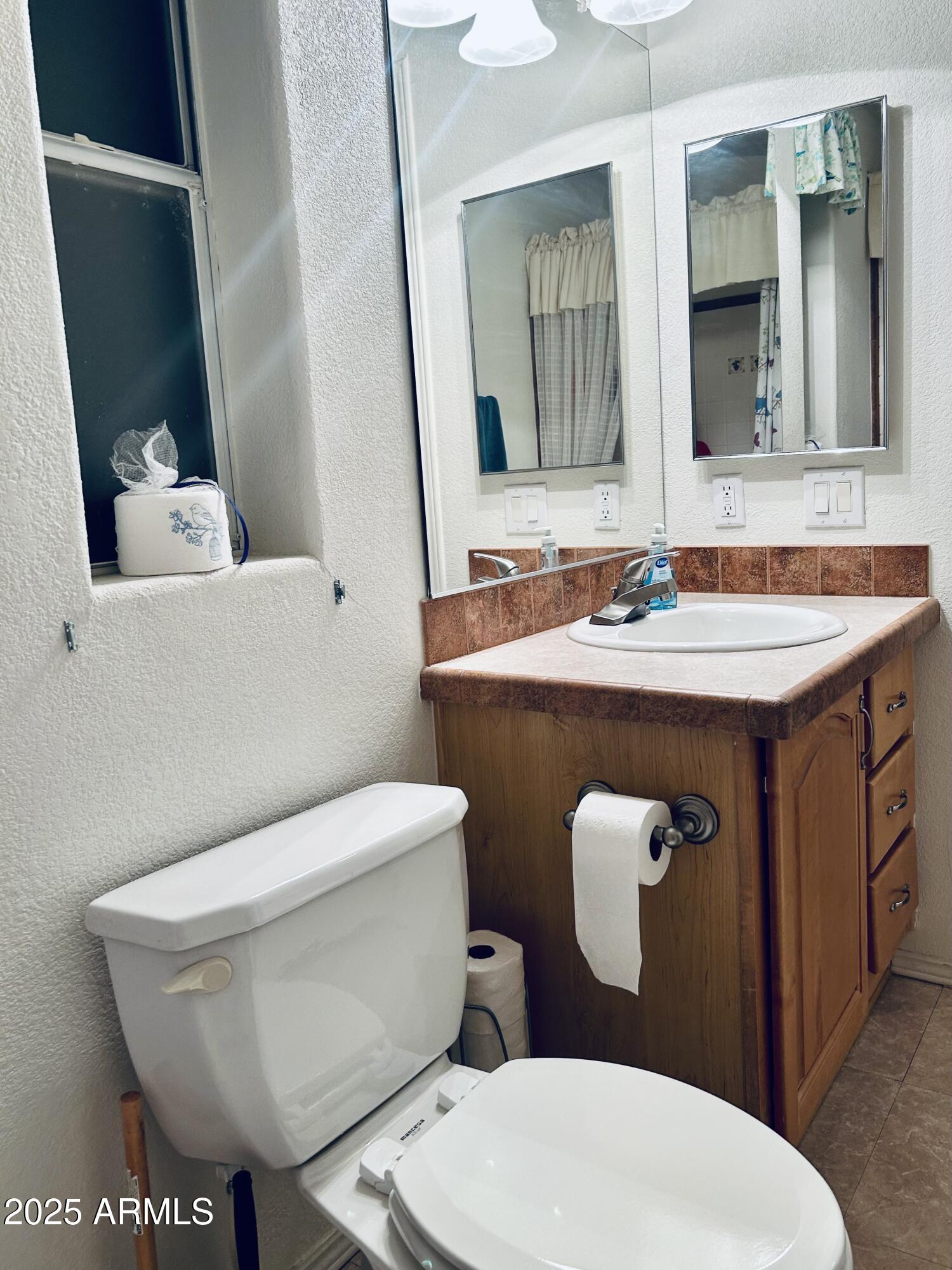 3301 South Goldfield Road, Unit 3011 Apache Junction, AZ 85119 - Photo 25 of 65 a white toilet sitting next to a bathroom sink