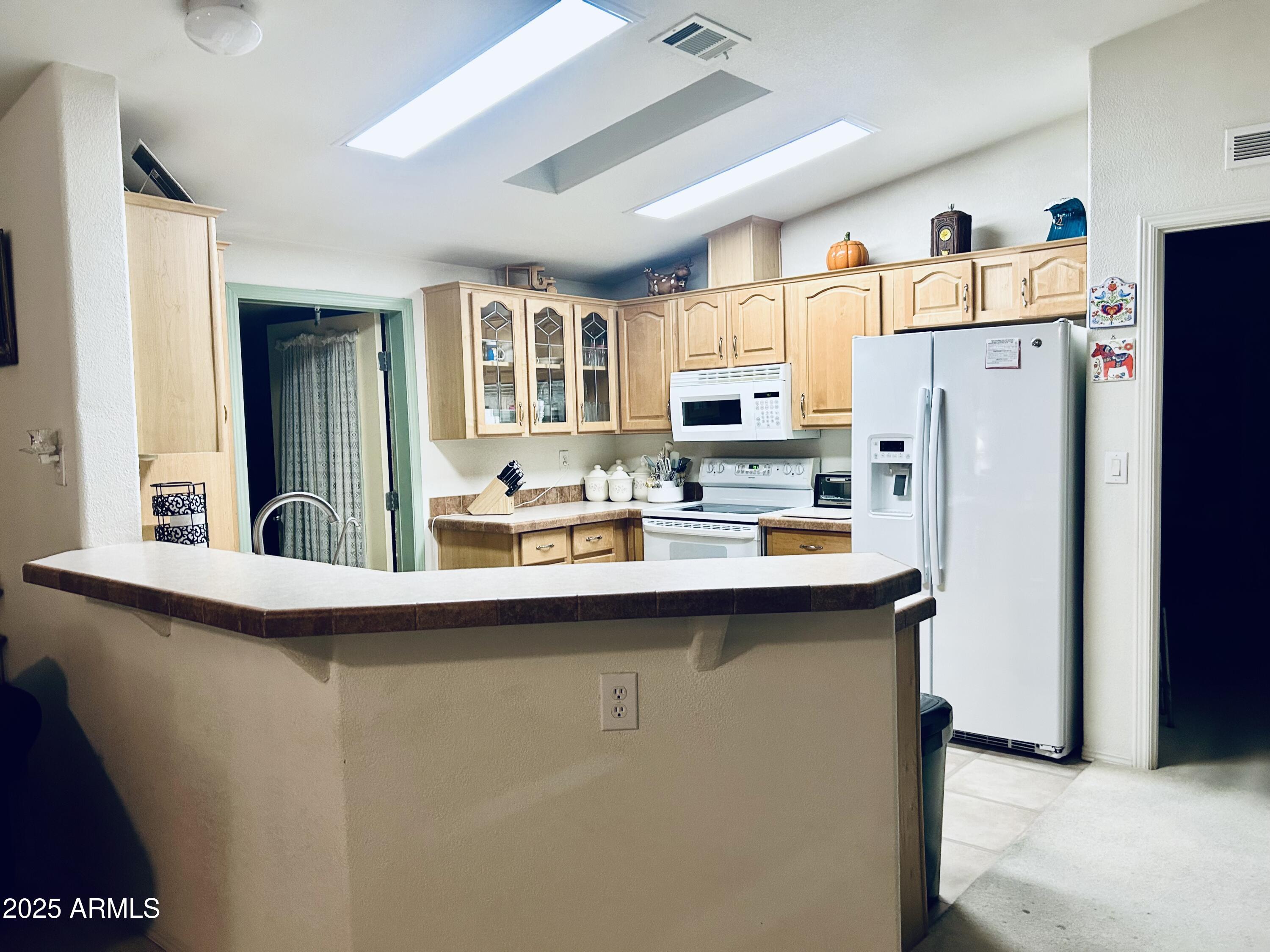 3301 South Goldfield Road, Unit 3011 Apache Junction, AZ 85119 - Photo 35 of 65 a kitchen with kitchen island a sink a refrigerator and a stove