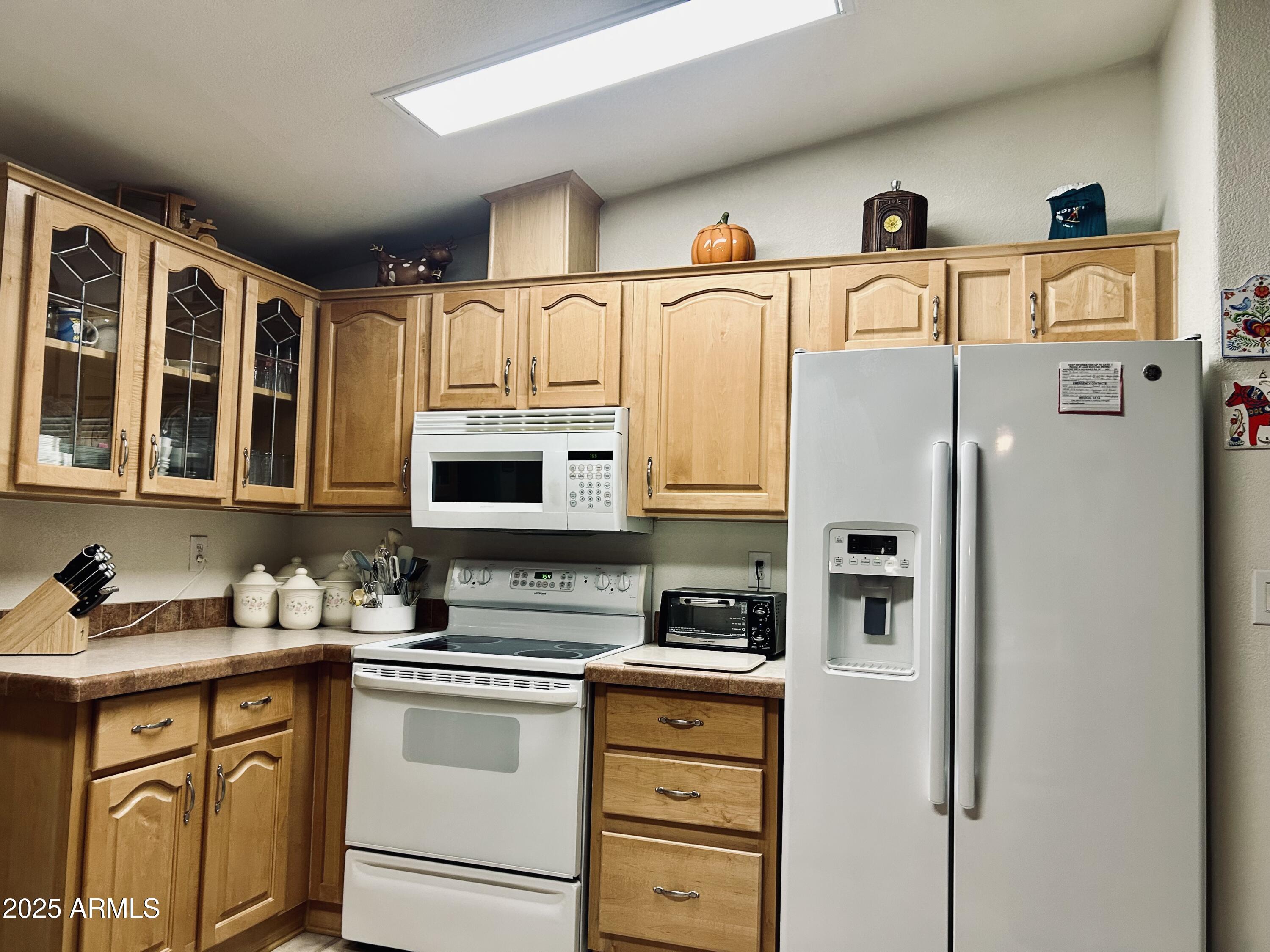 3301 South Goldfield Road, Unit 3011 Apache Junction, AZ 85119 - Photo 38 of 65 a kitchen with stainless steel appliances a refrigerator sink and cabinets