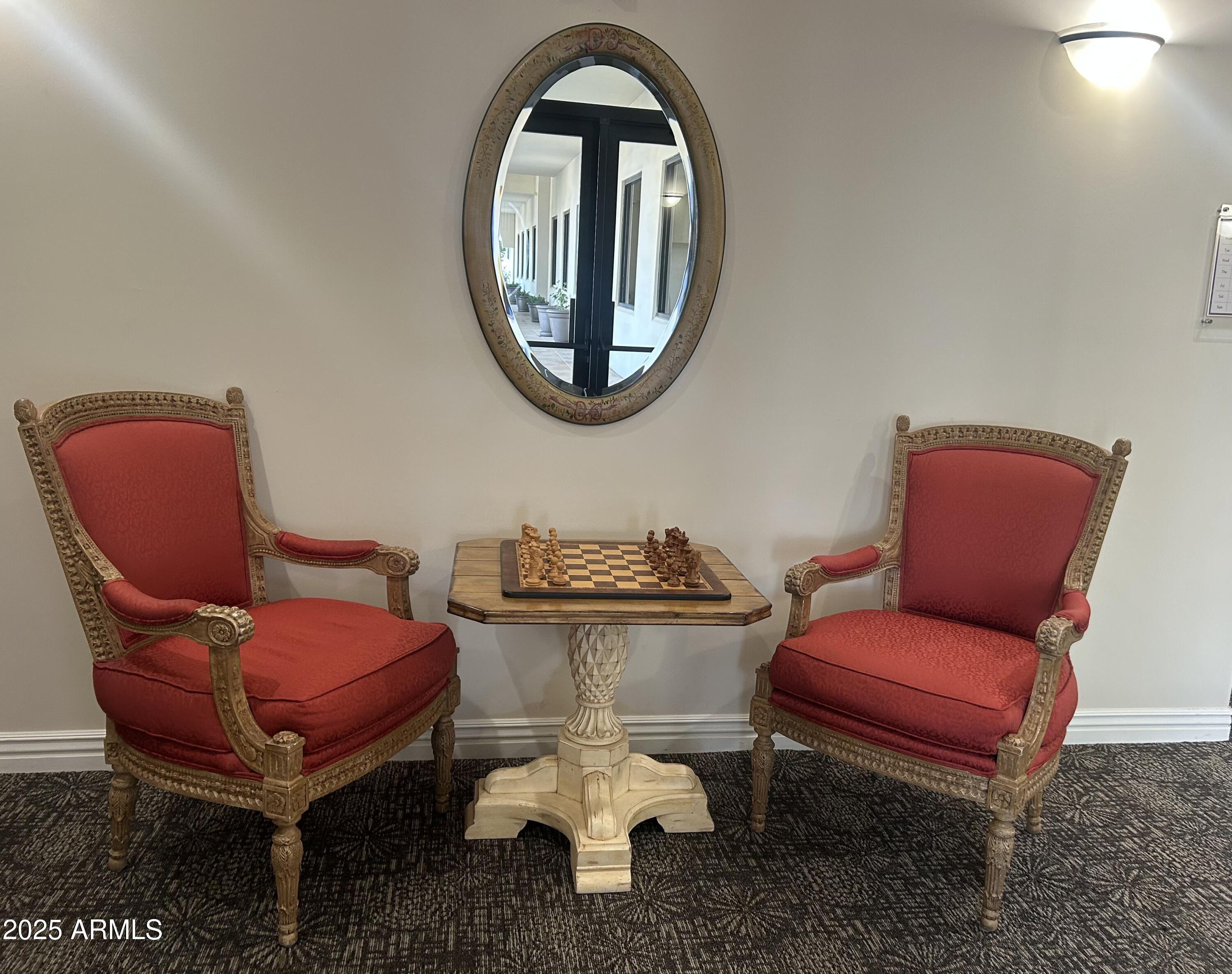 3301 South Goldfield Road, Unit 3011 Apache Junction, AZ 85119 - Photo 51 of 65 a living room with furniture a mirror and a chair