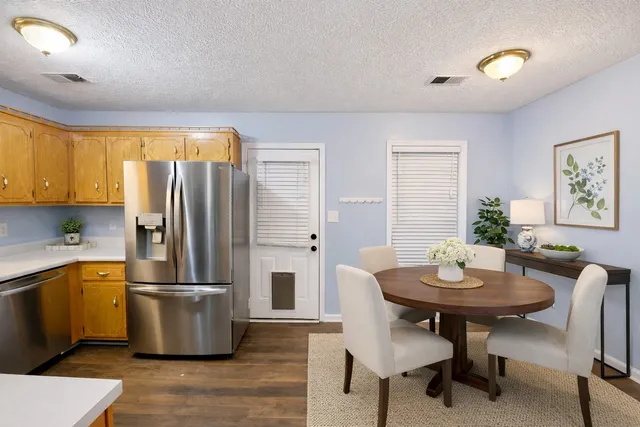 a kitchen with stainless steel appliances wooden floor and dining table
