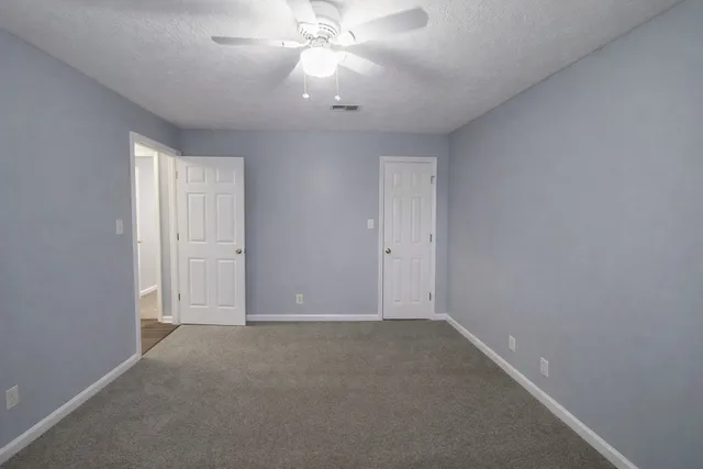 an empty room with a ceiling fan and a window