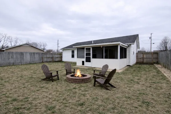 a view of a backyard with table and chairs and a barbeque