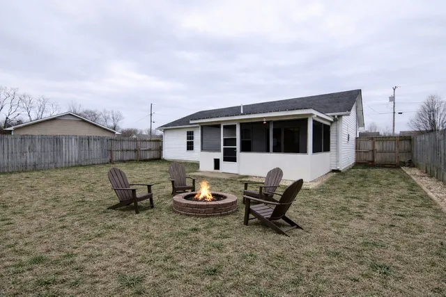 a view of a backyard with table and chairs and a barbeque