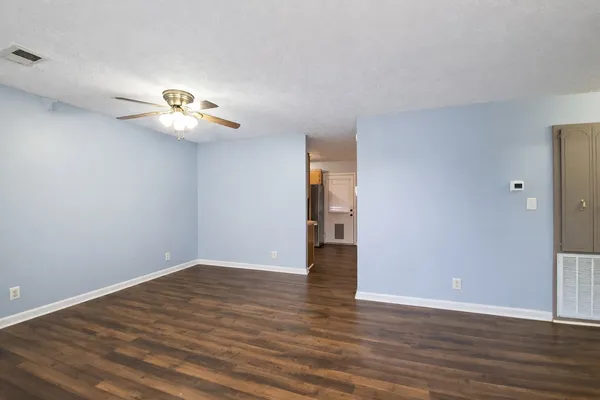 a view of empty room with wooden floor and window