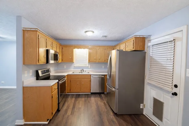 a kitchen with a refrigerator a stove top oven a sink and dishwasher