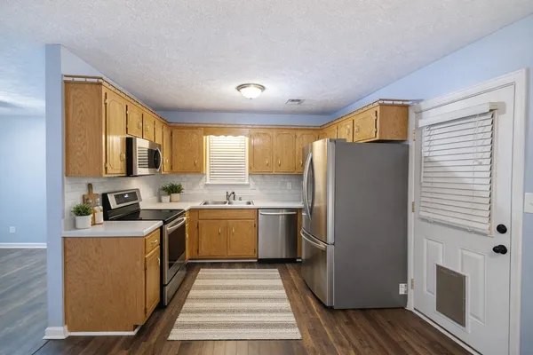a kitchen with a refrigerator a stove top oven a sink and dishwasher