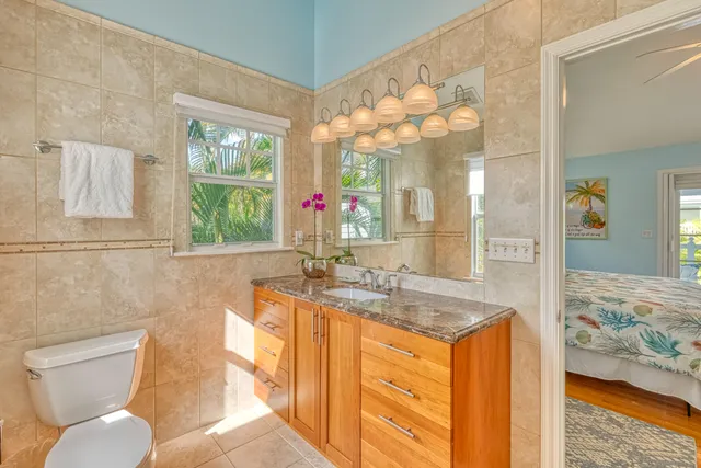 a bathroom with a granite countertop sink mirror vanity and toilet