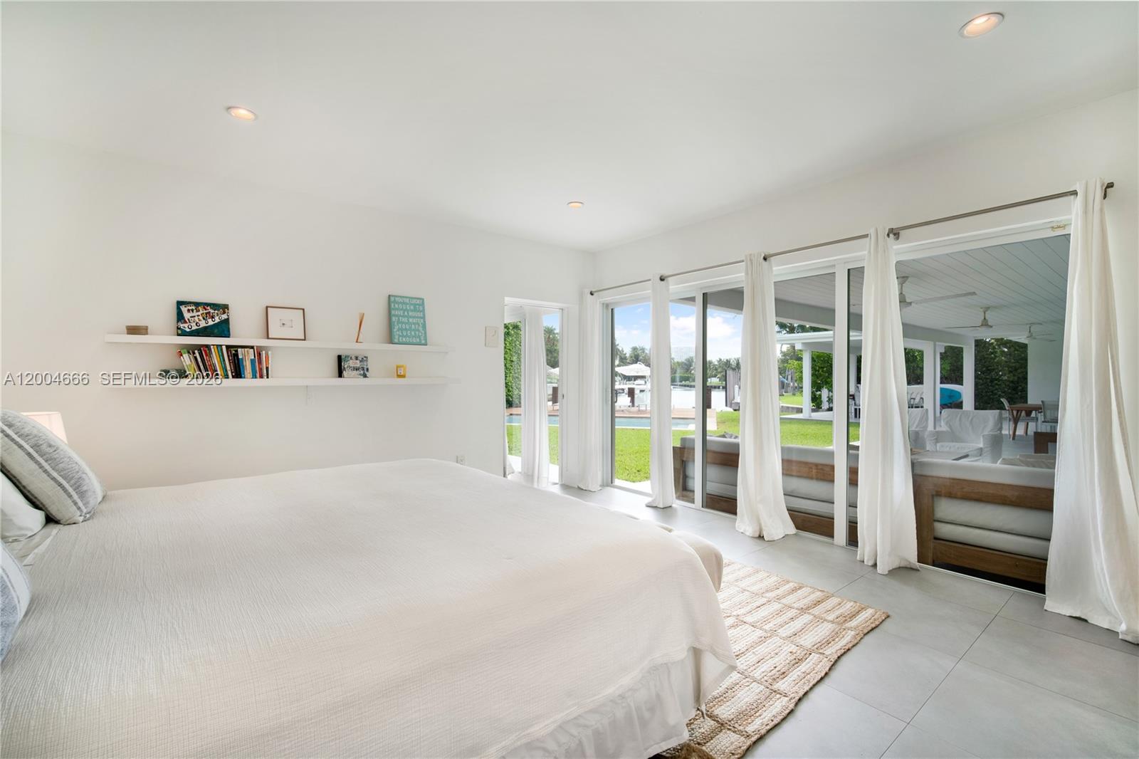 861 Harbor Drive Key Biscayne, FL 33149 - Photo 21 of 33 a spacious bedroom with a large bed and a chandelier
