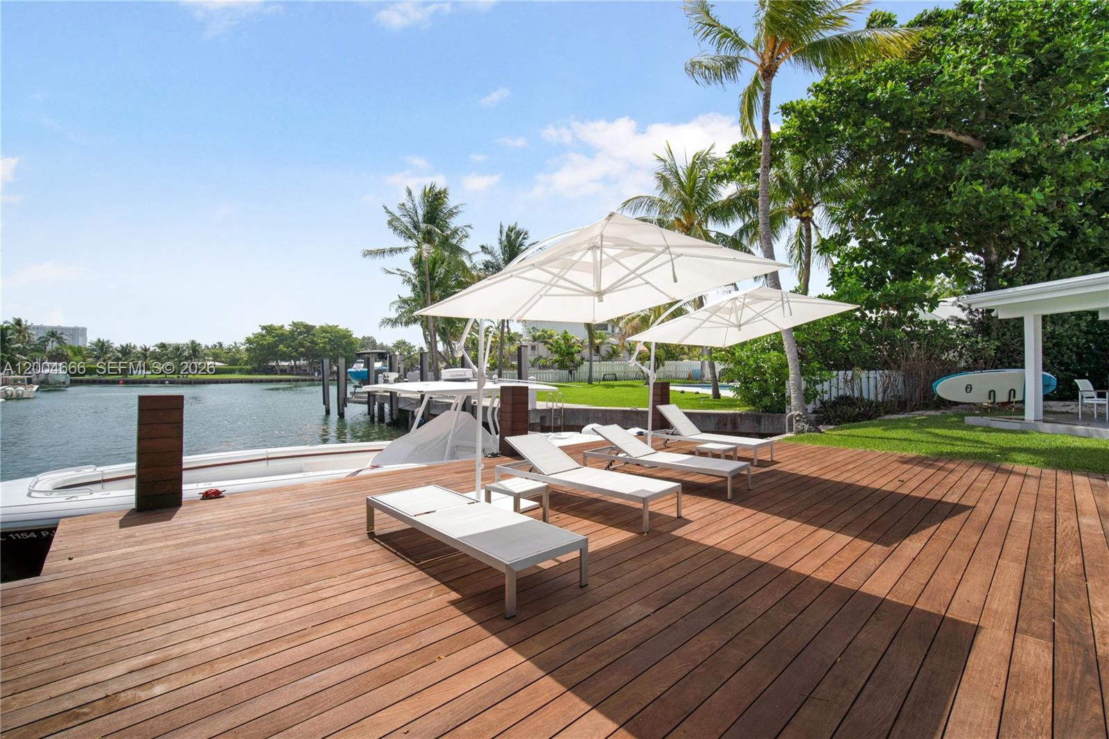 861 Harbor Drive Key Biscayne, FL 33149 - Photo 5 of 33 a view of a patio with couches table and chairs with wooden floor and fence