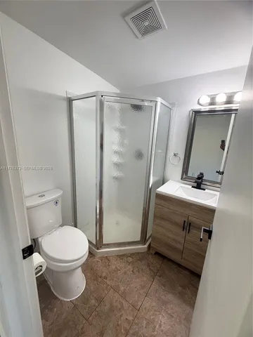 a bathroom with a sink a toilet a mirror and shower