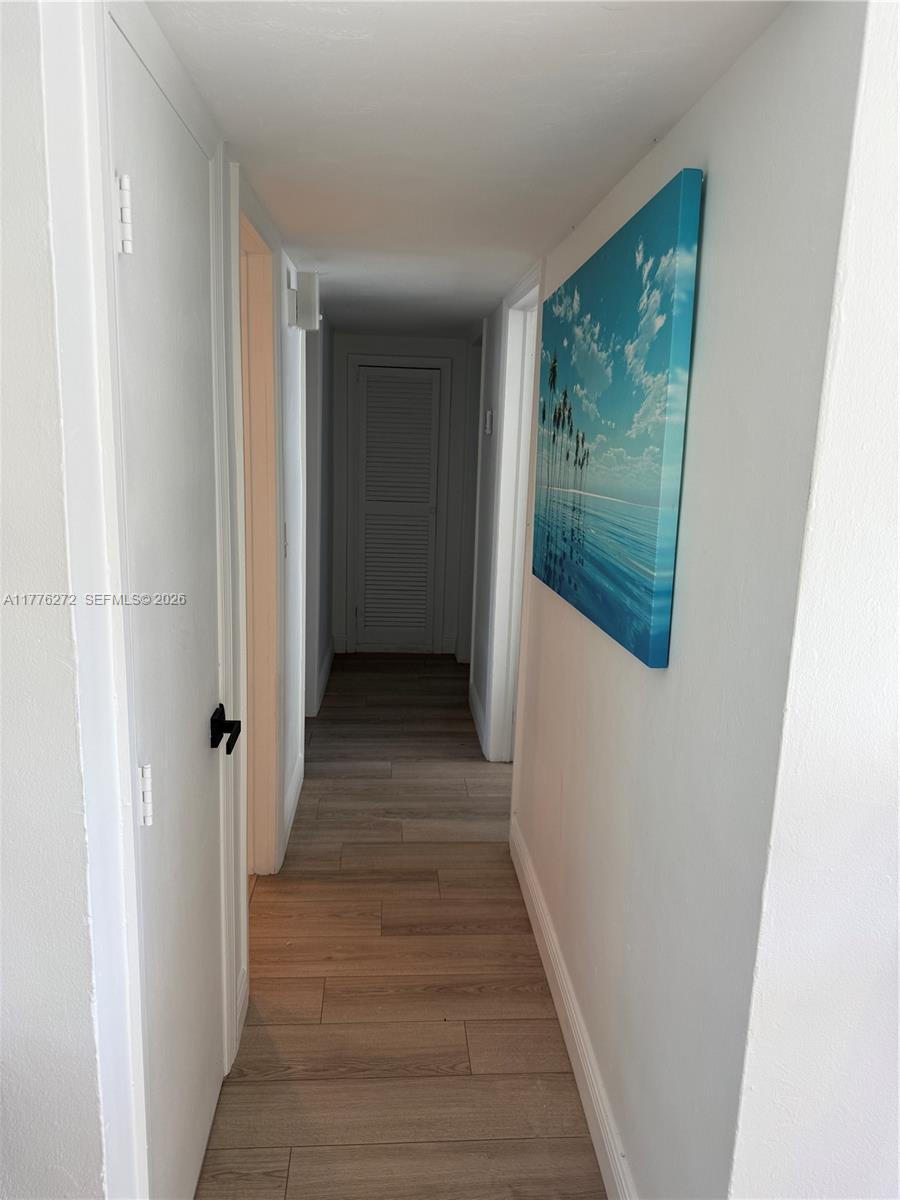5001 Northeast 23rd Avenue Lighthouse Point, FL 33064 - Photo 23 of 49 a view of a hallway with wooden floor and a bathroom