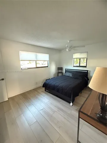 a bedroom with a large bed and a lamp on table