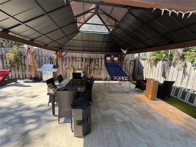 a view of swimming pool with lawn chairs under an umbrella
