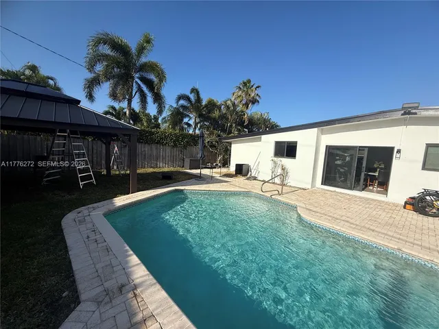 a view of a house with backyard and sitting area