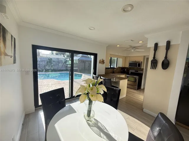 a dining room with furniture a large window and a chandelier