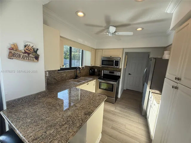 a kitchen with stainless steel appliances granite countertop a sink stove and refrigerator